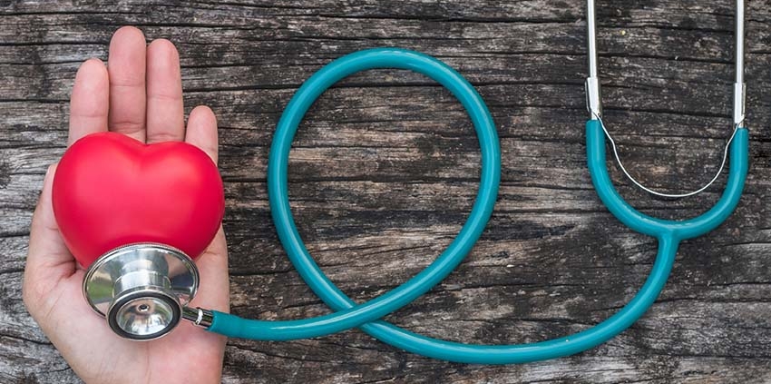 Hand holding heart shaped ball and stethoscope