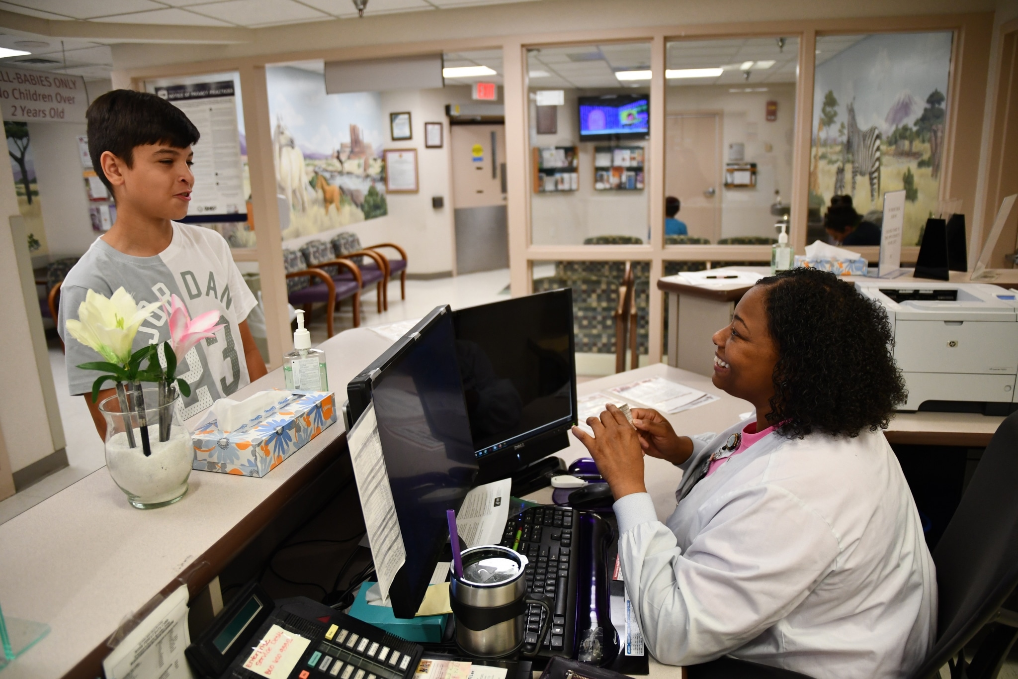 Smiling medical assistant with a young patient