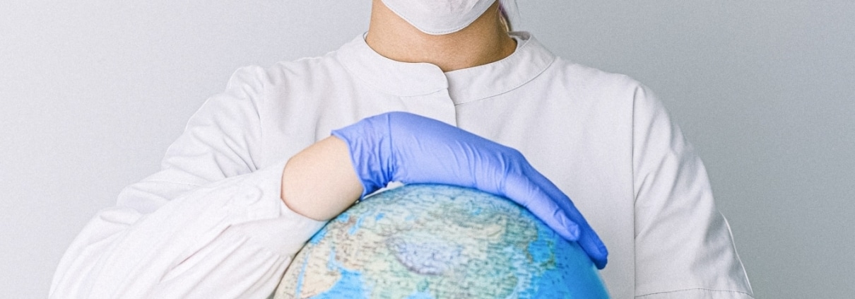 Medical professional holding a globe
