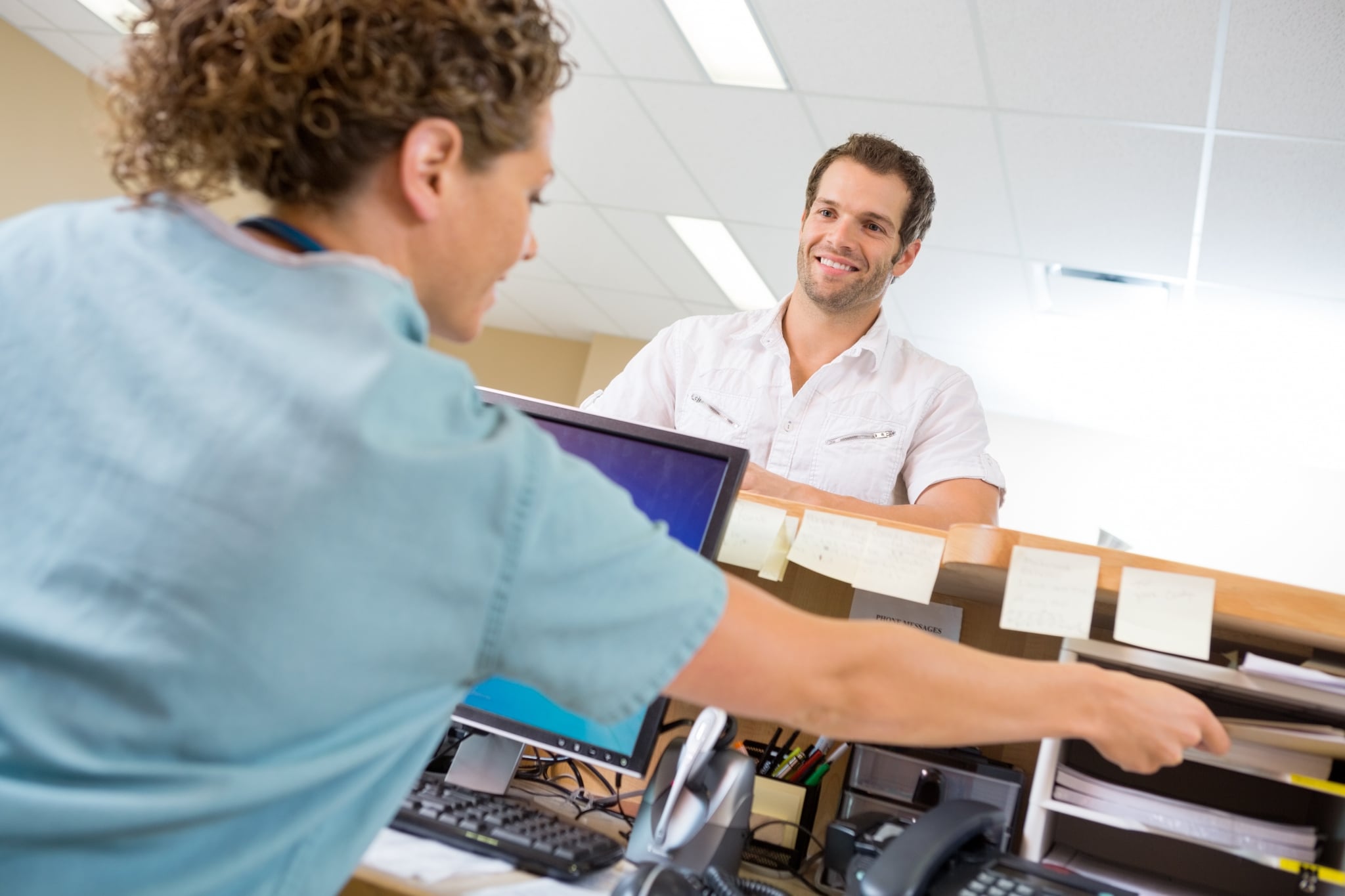 Medical receptionist working at a desk