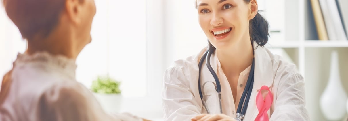 Healthcare professional holding the hand of an oncology patient