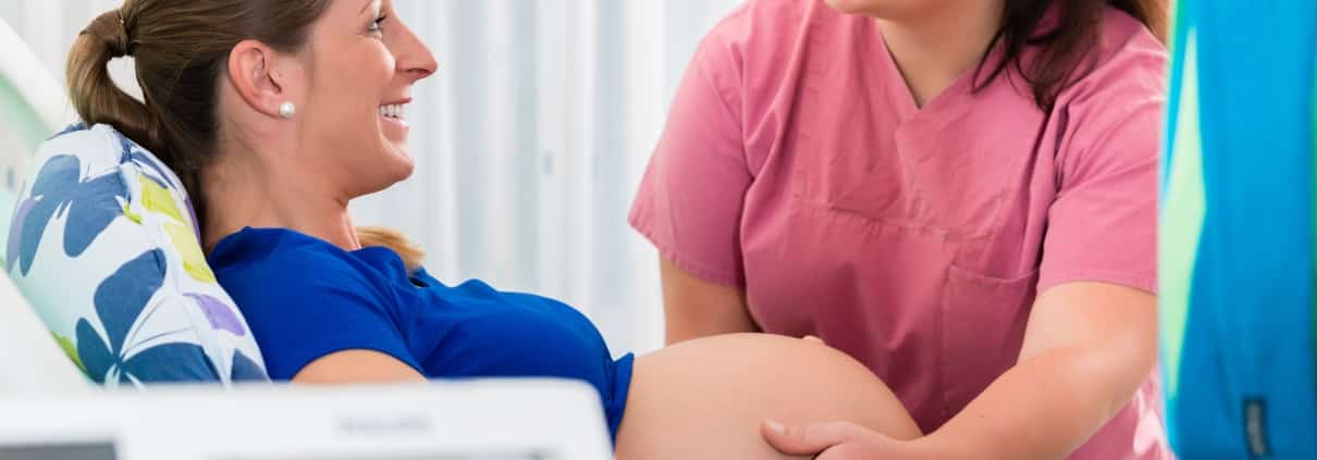 Midwife assisting a pregnant woman in the delivery room