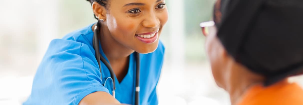 Caring African-American nurse with a patient
