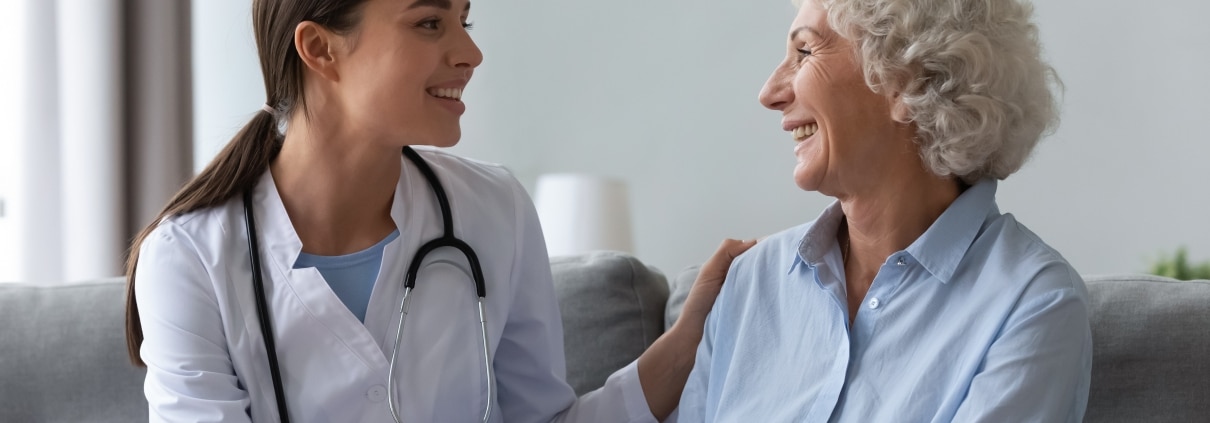 Happy young nurse with elderly patient