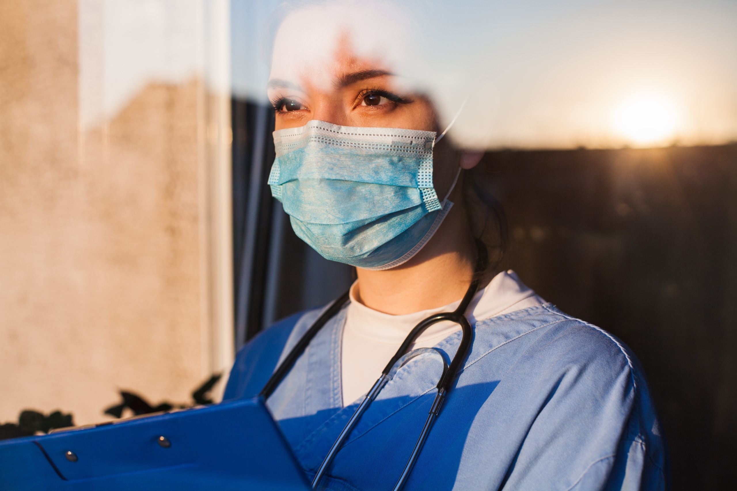 Young nurse looking through a window