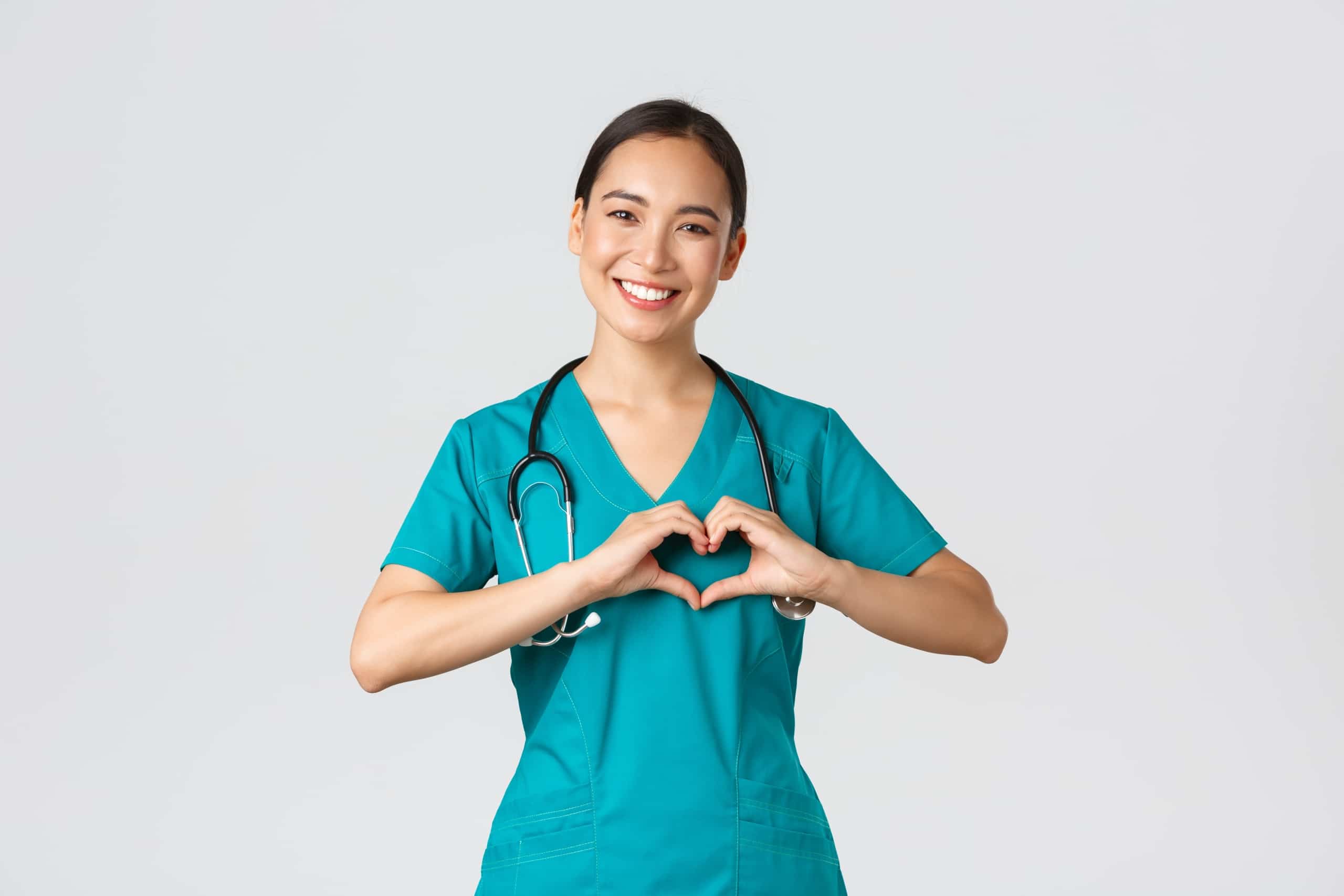 Smiling nurse forming a heart with her hands