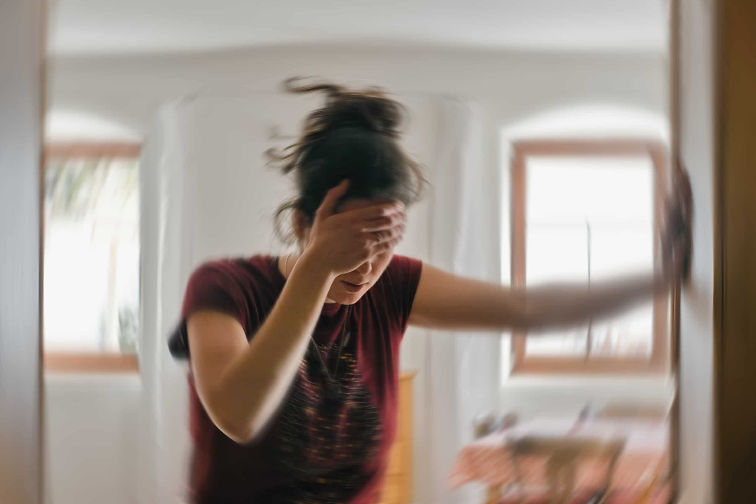 Blurred photo of a woman holding her head
