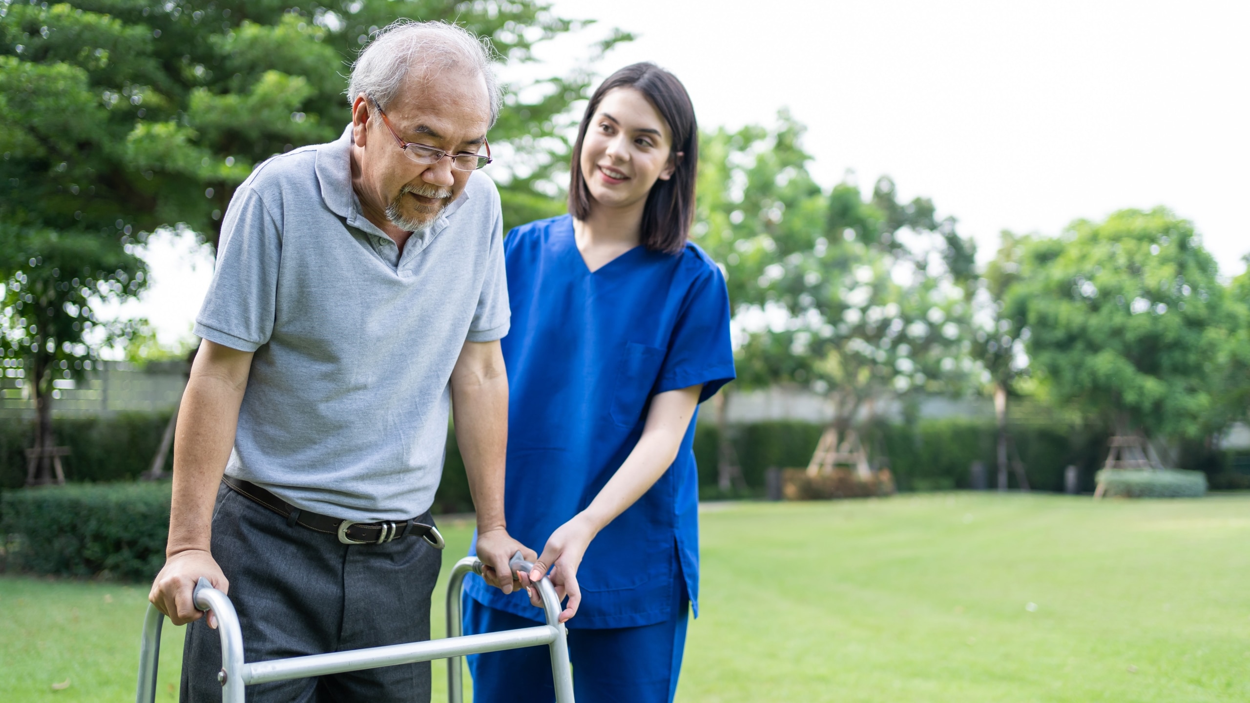 Young medical professional with an elderly patient outside