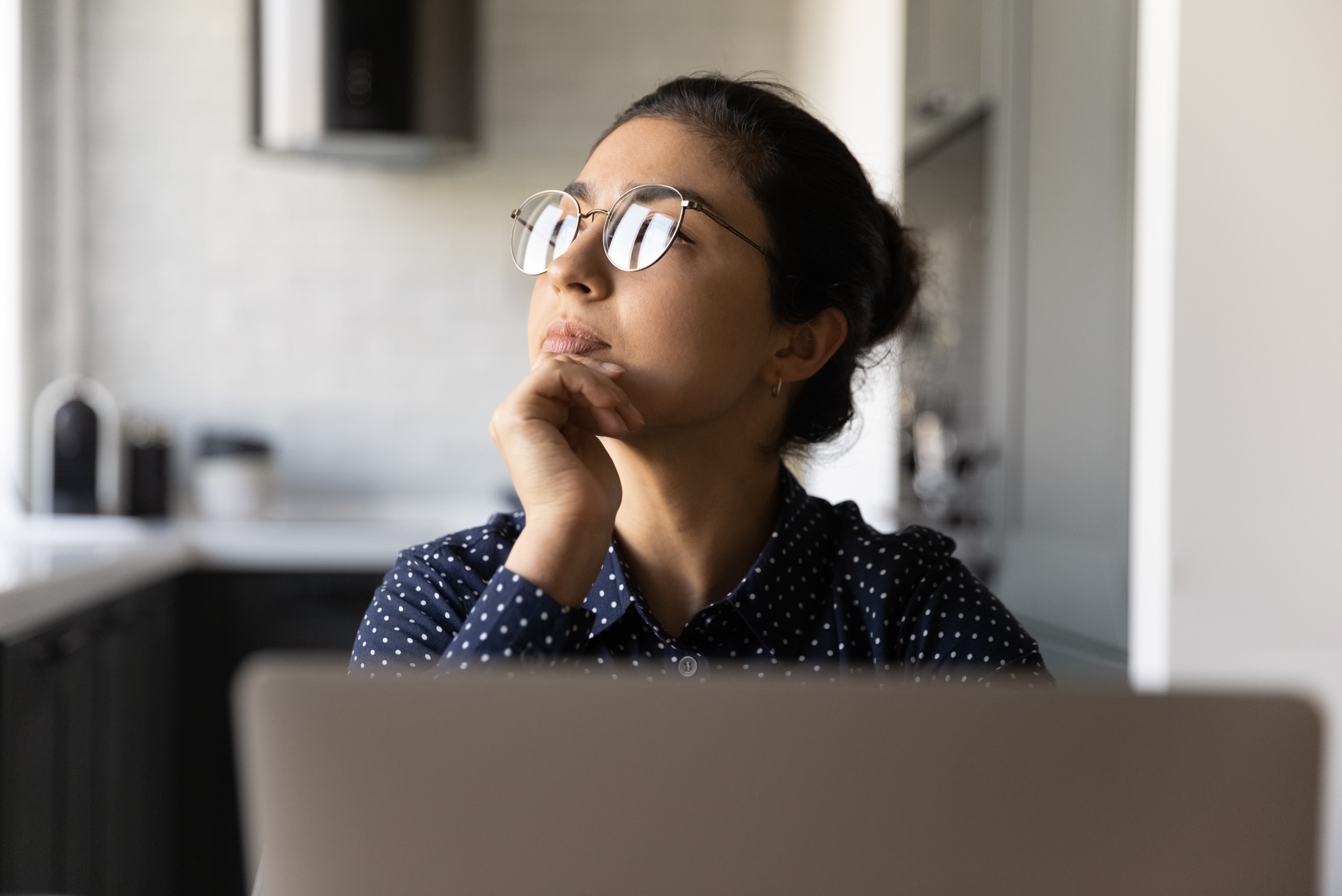 Young woman wearing glasses while deep in thought