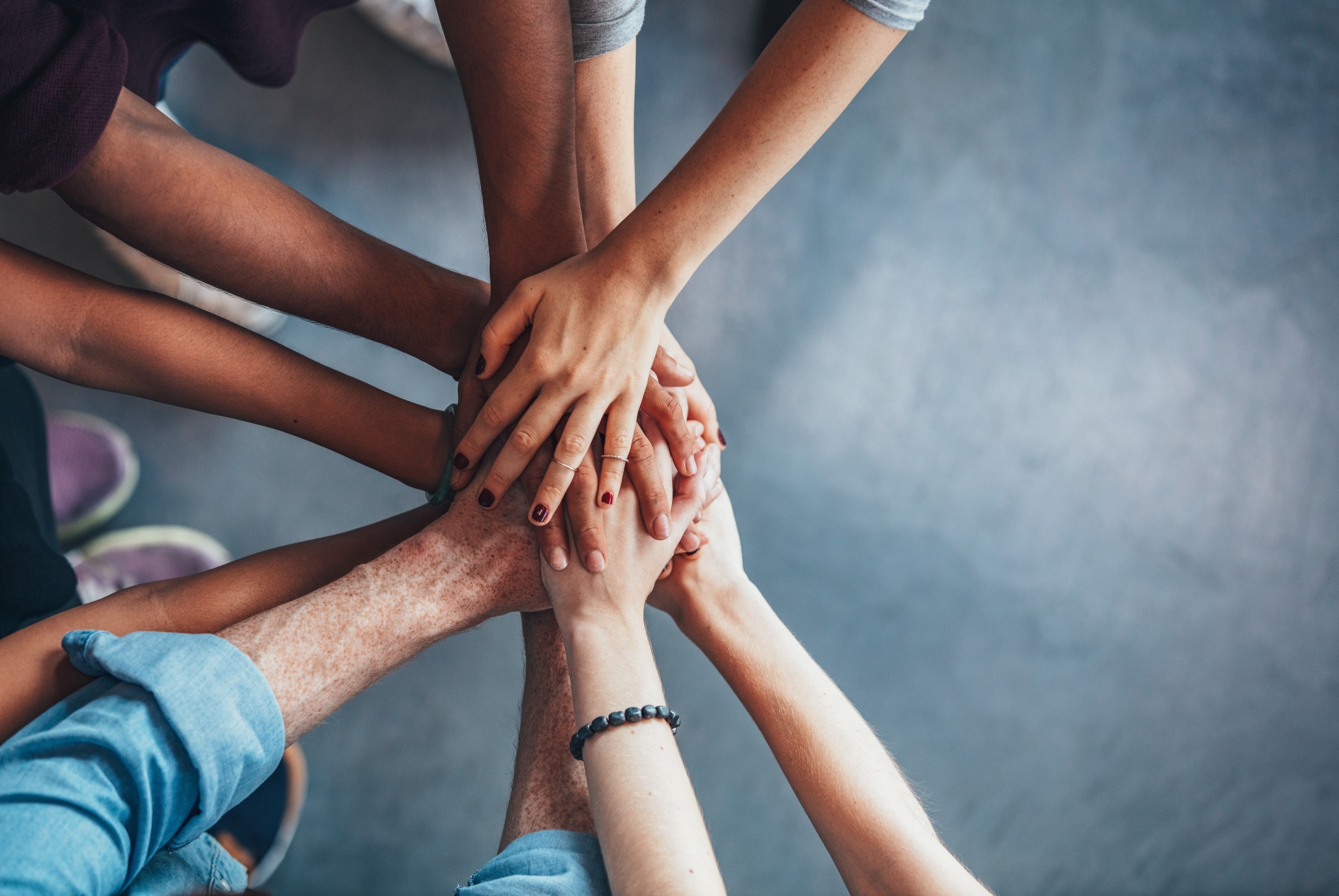Close up of people touching hands as a gesture of teamwork