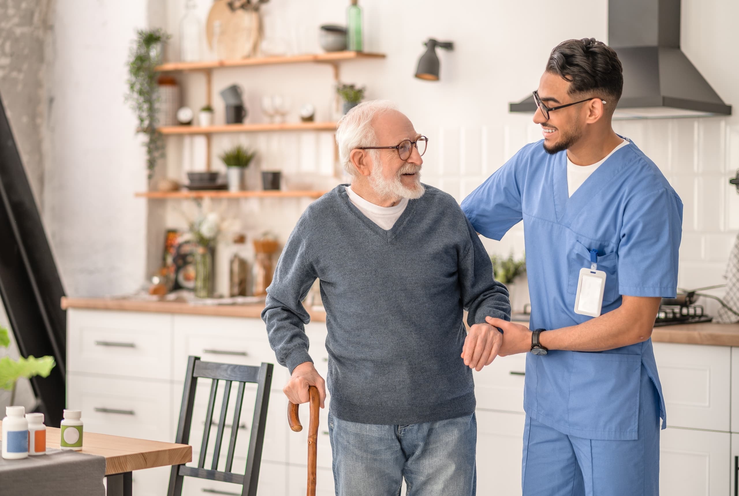 Male medical professional helping an elderly man walk