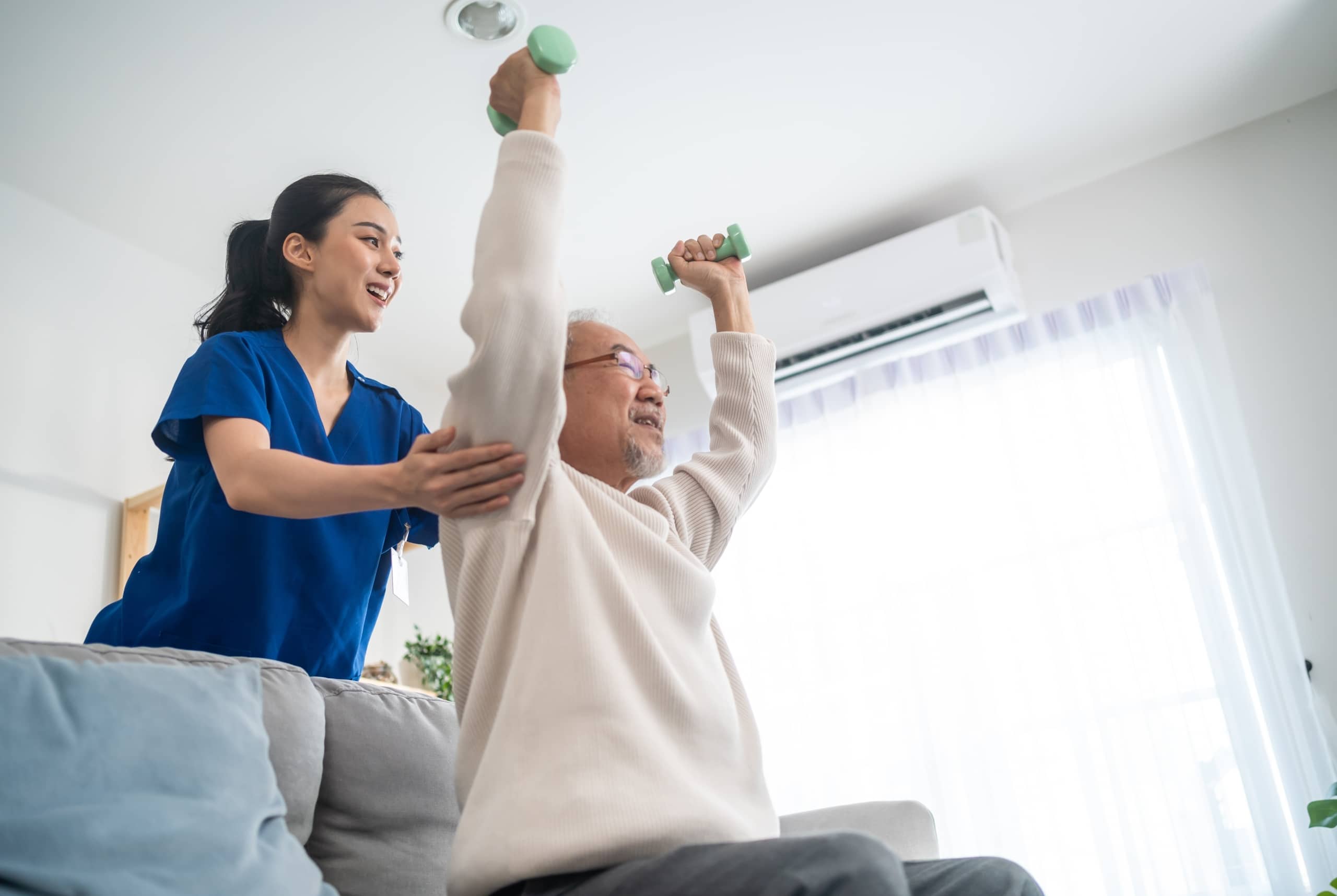 Asian medical professional helping an elderly man perform exercises