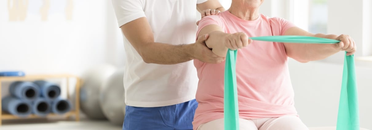 Elderly woman performing physical therapy exercises