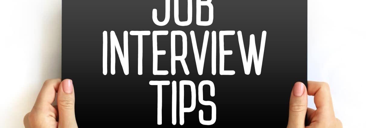 Hands holding a board that says job interview tips
