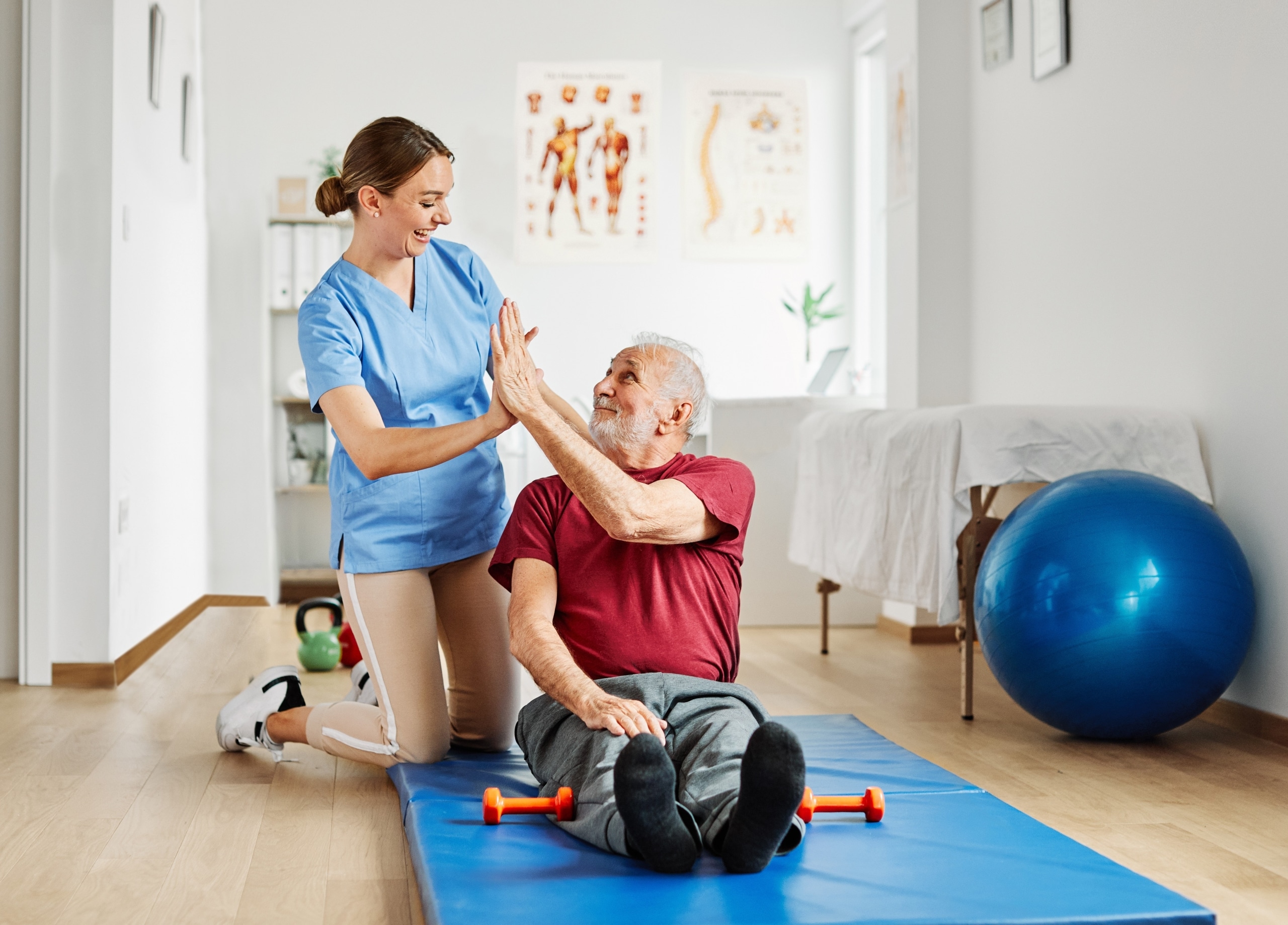 Physical Therapist Assistant high fiving an elderly patient