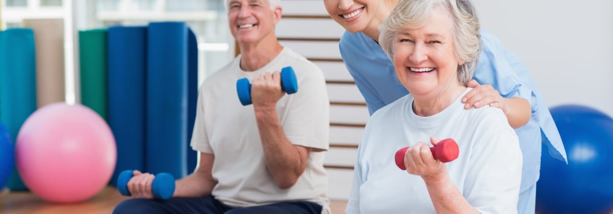 Elderly people using weights with a physical therapy professional
