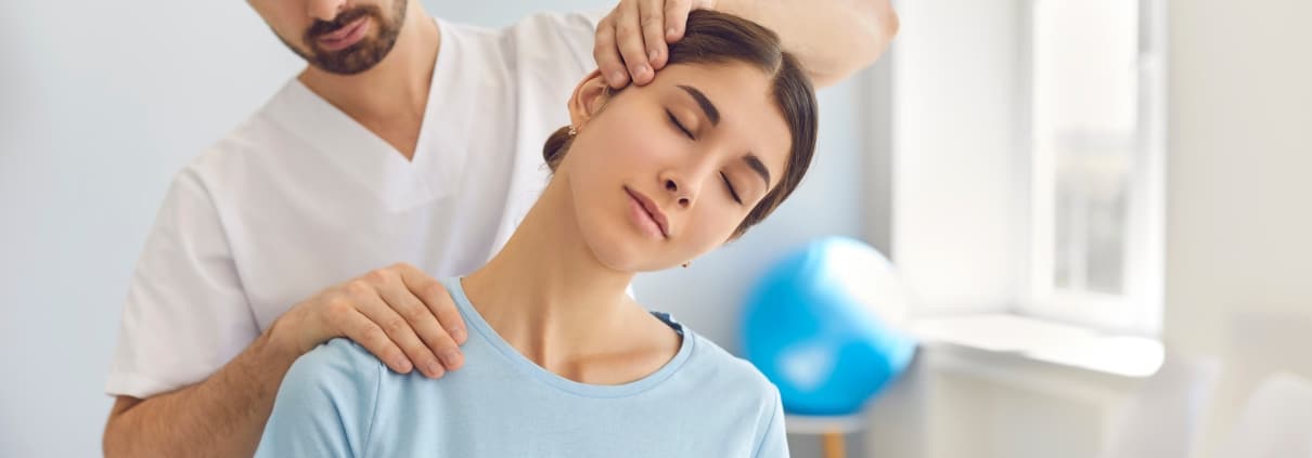 Physical therapy professional manipulating a woman's neck and shoulders