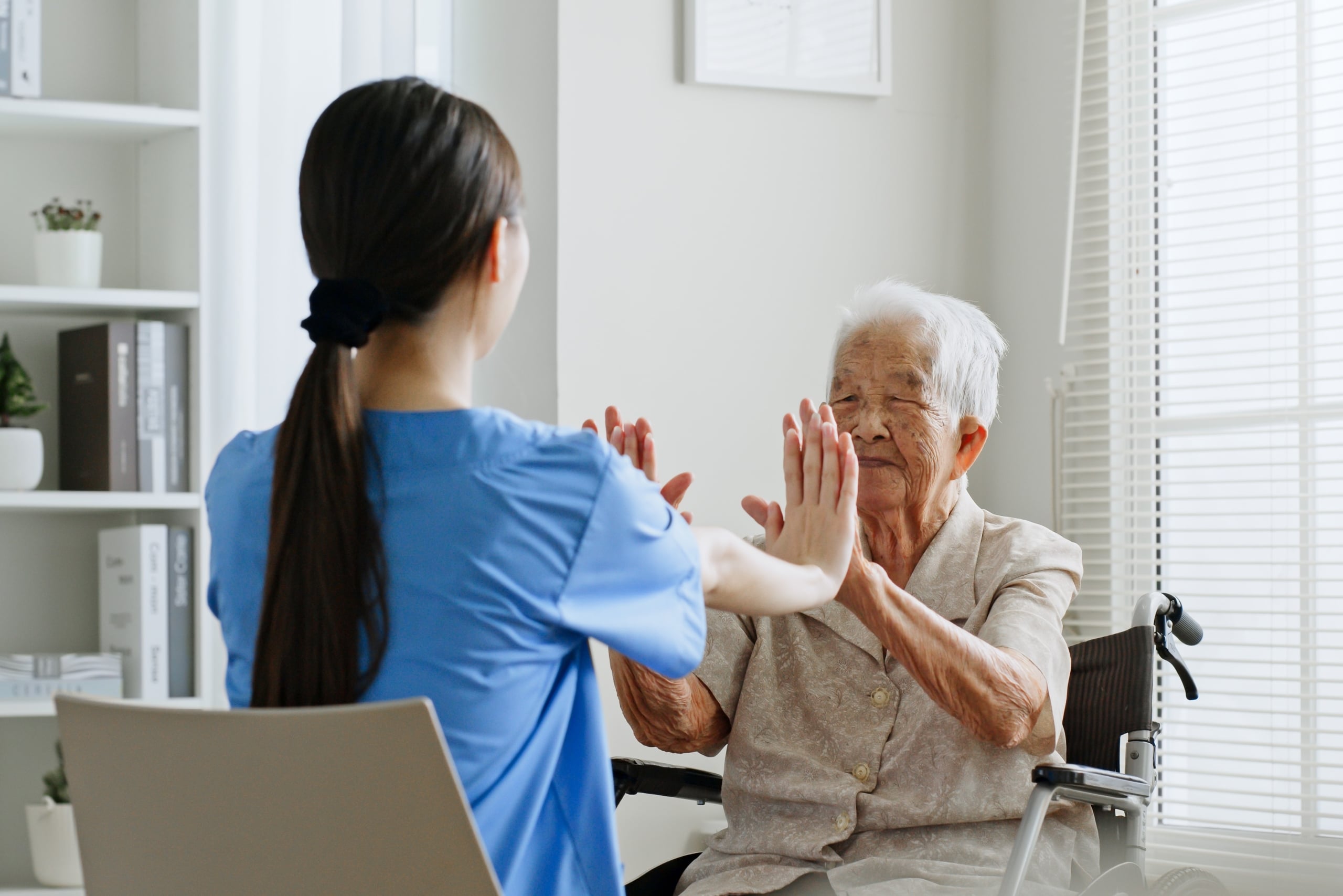 Medical professional helping an Asian man perform exercises