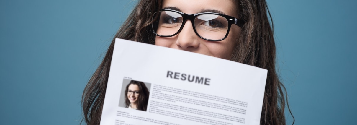 Woman with glasses holding up her resume