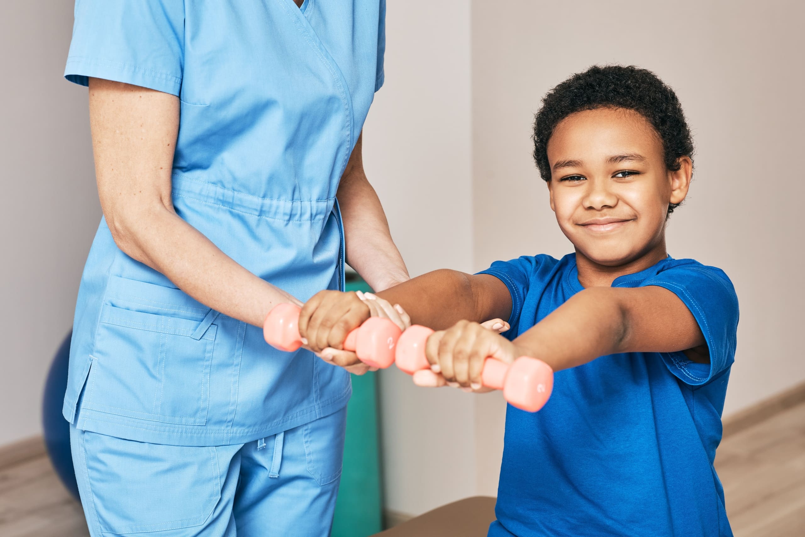 Close up of a young boy lifting weights in physical therapy