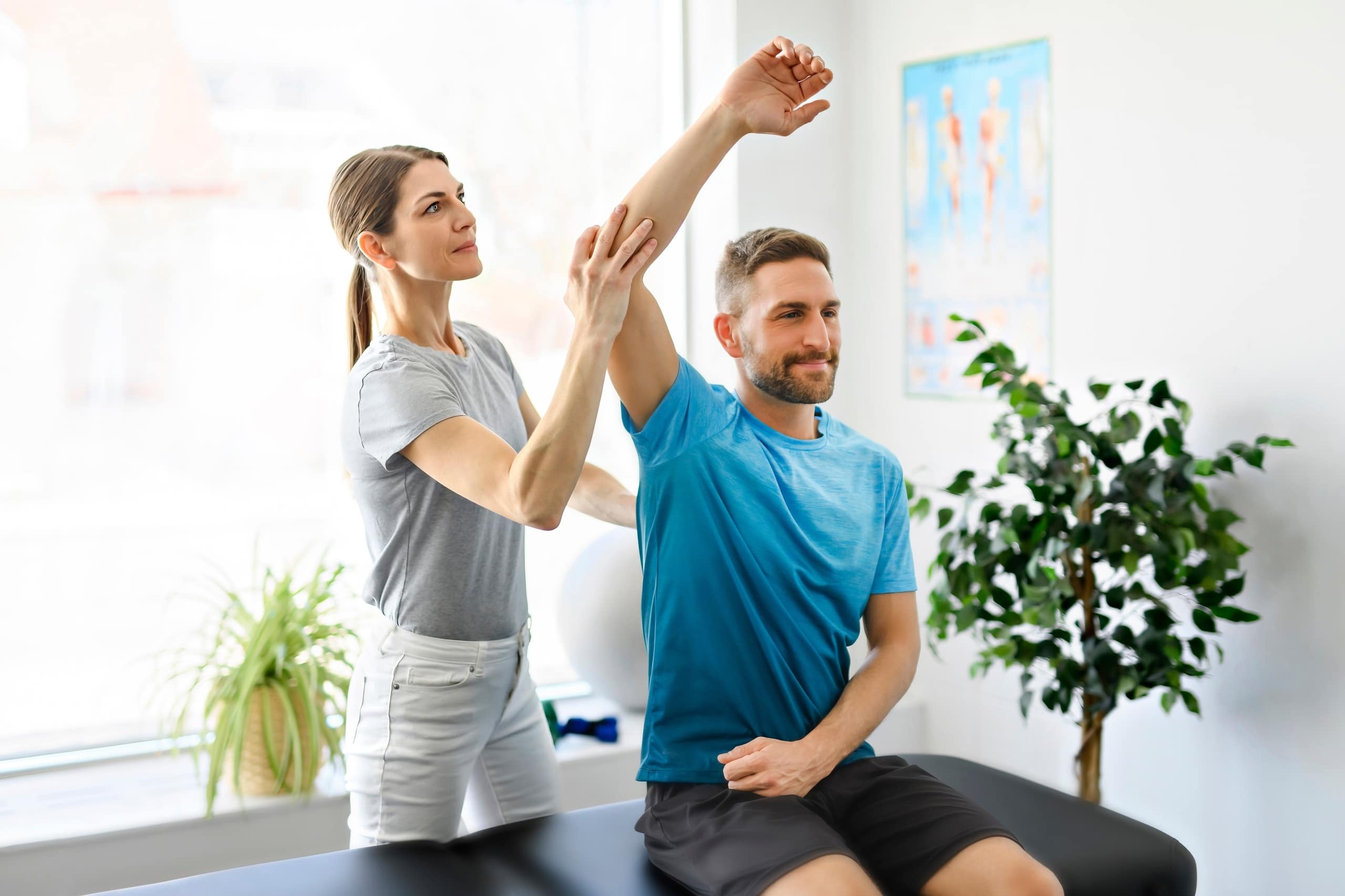 Physical therapy professional helping a man stretch his arm