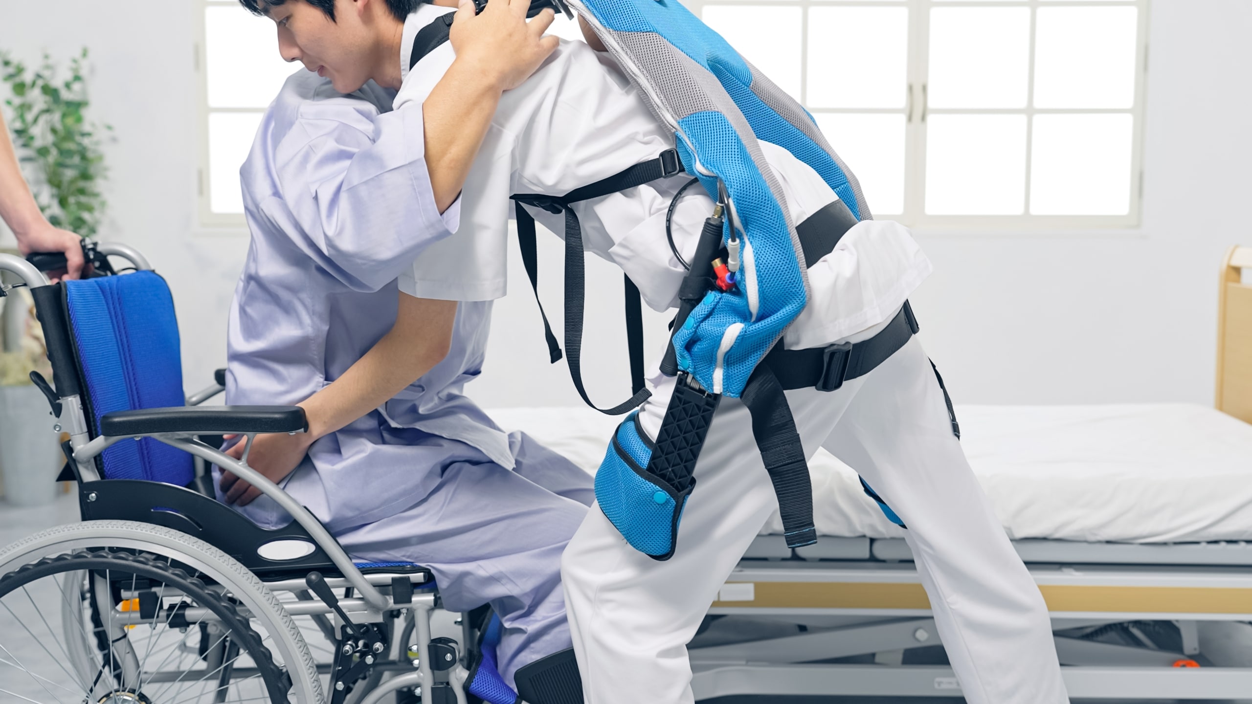 Medical professional wearing a power suit to assist while lifting a patient