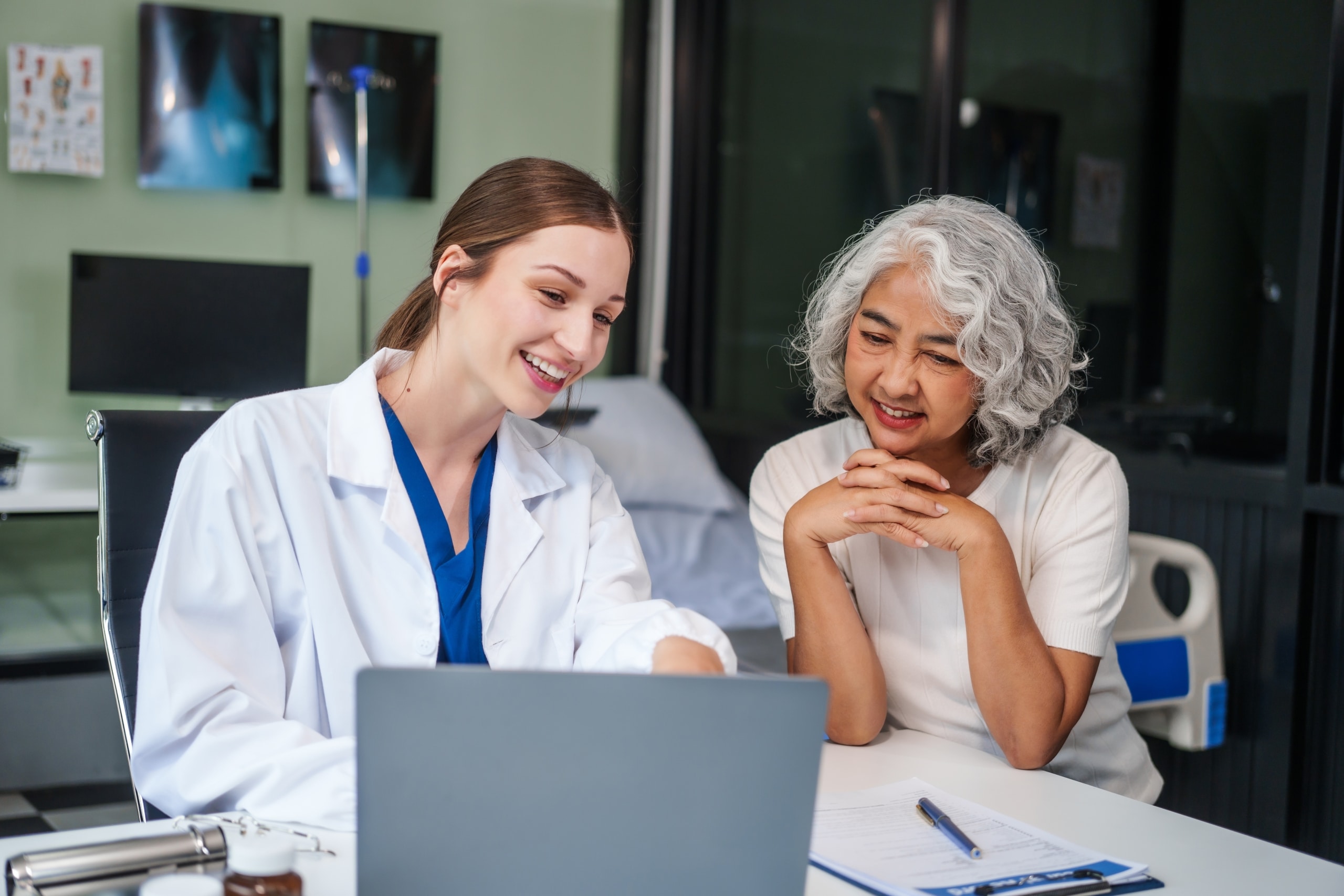 Young medical professional speaking with an older Asian woman