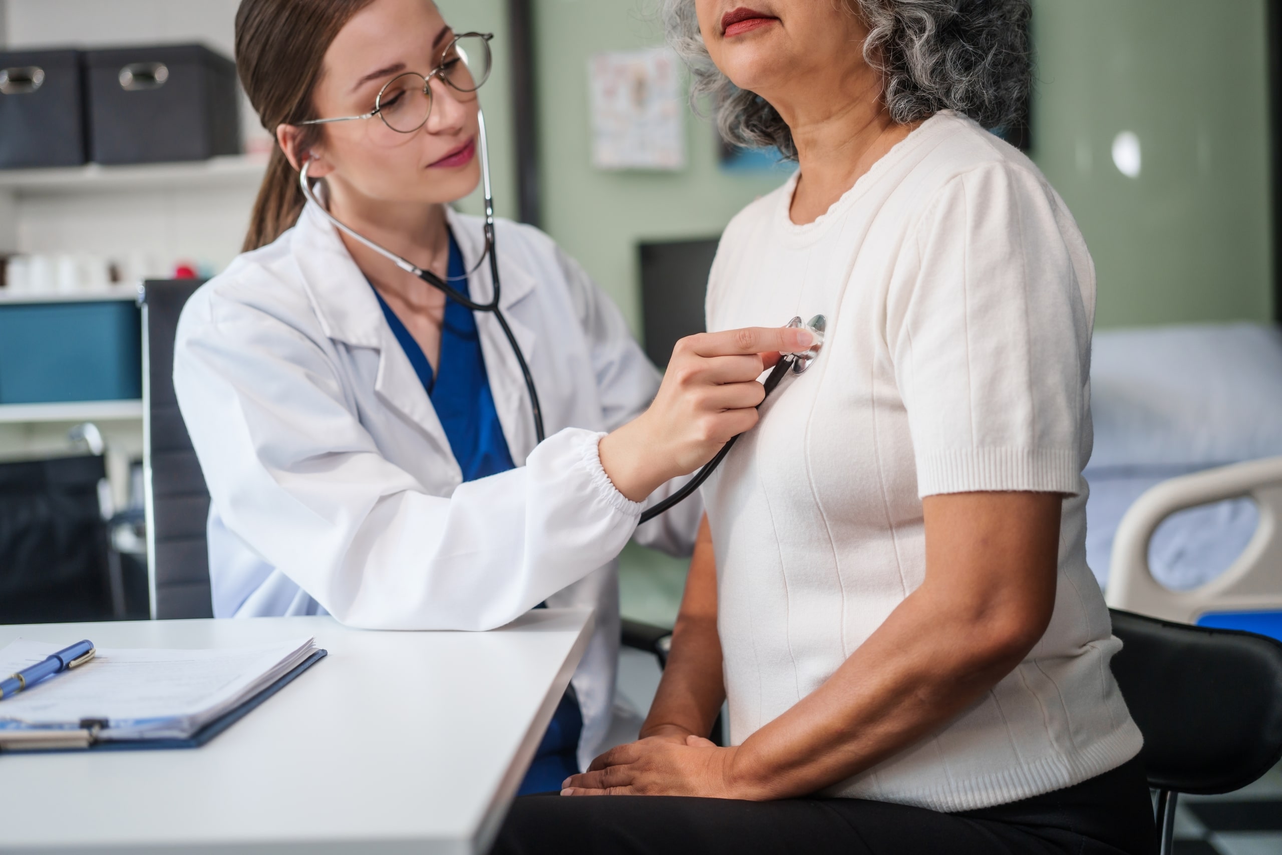 Caucasian medical professional taking a woman's heartbeat