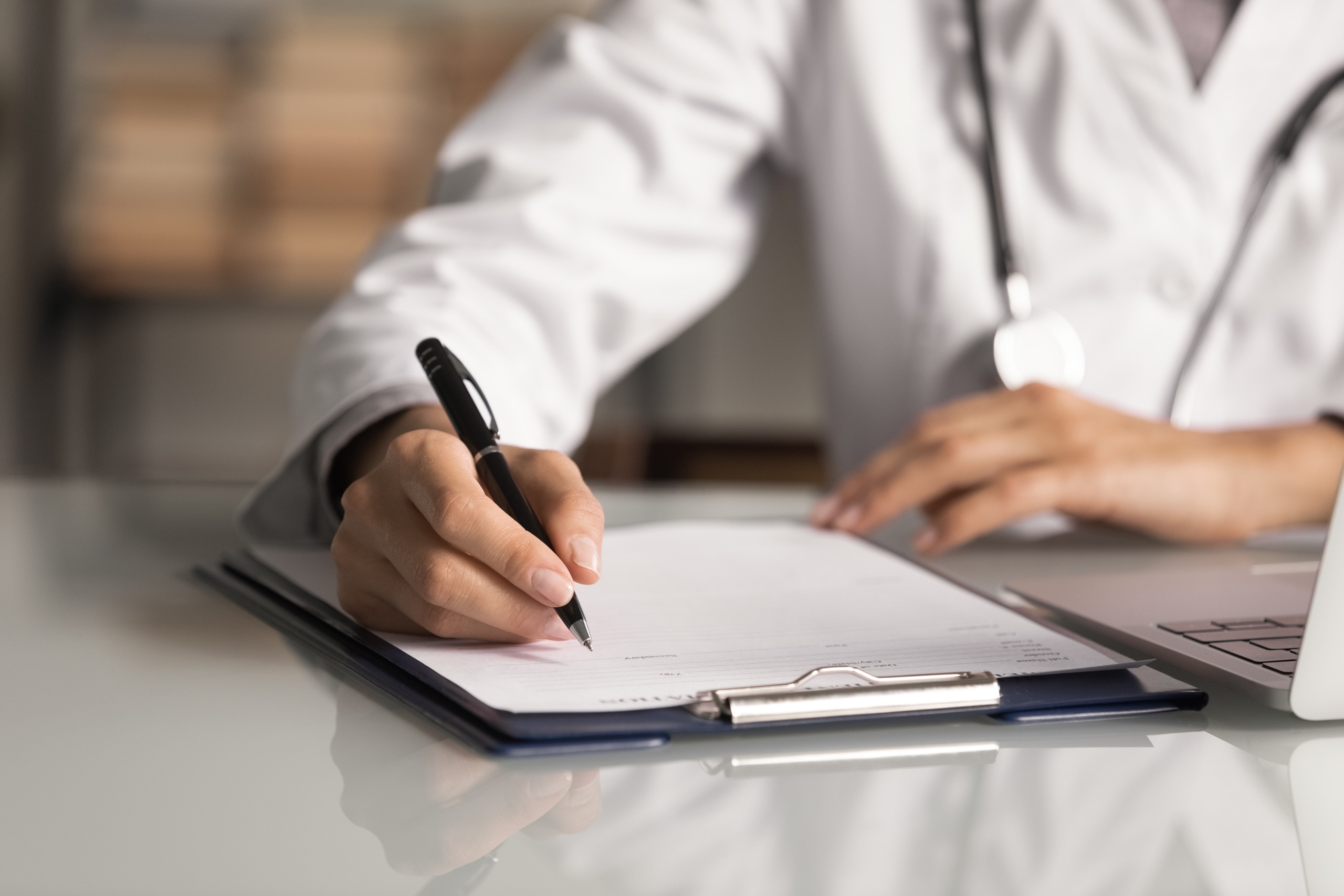 Close up of a medical professional filling out paperwork