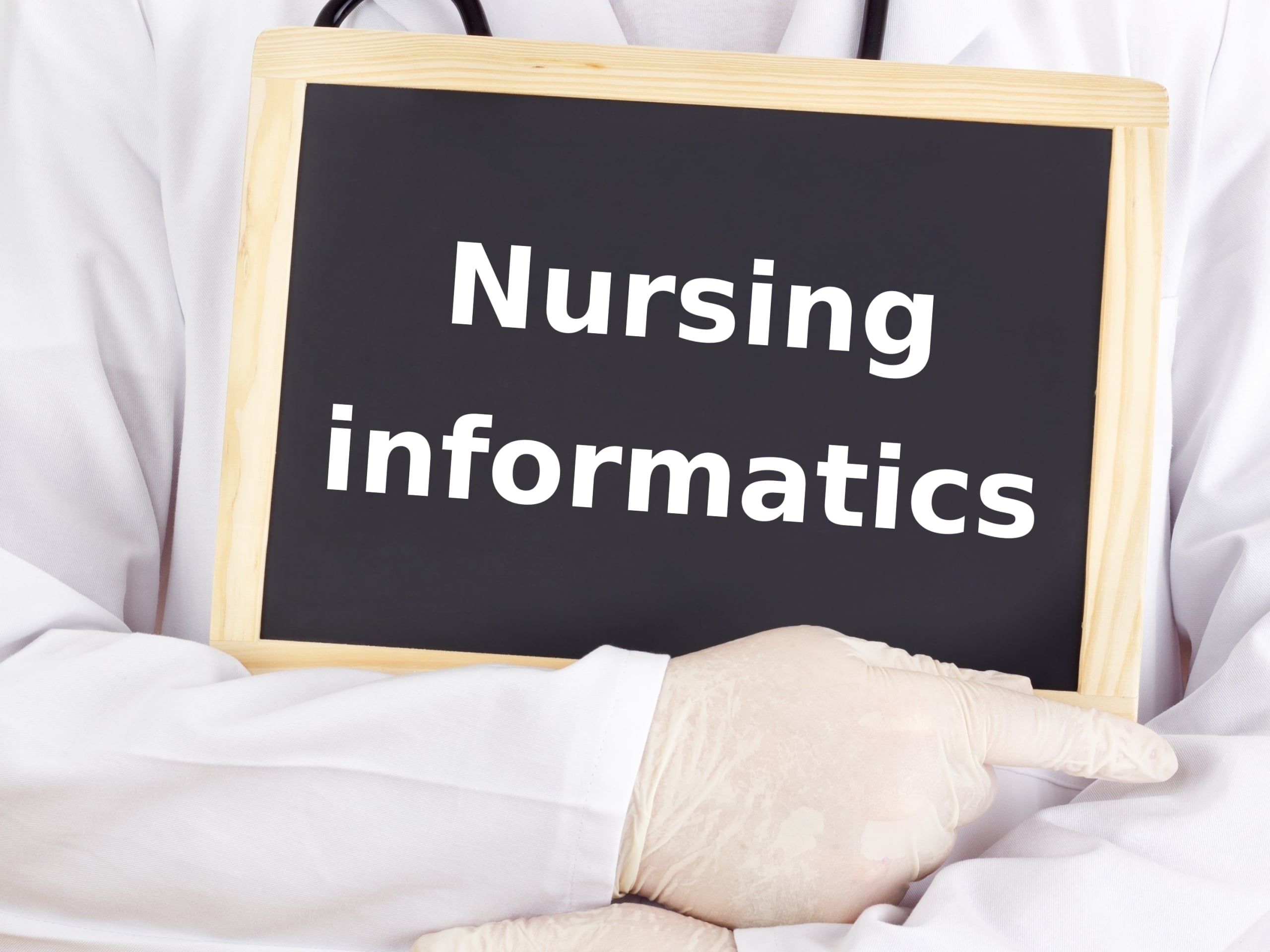Close up of a medical professional holding a sign that says nursing informatics