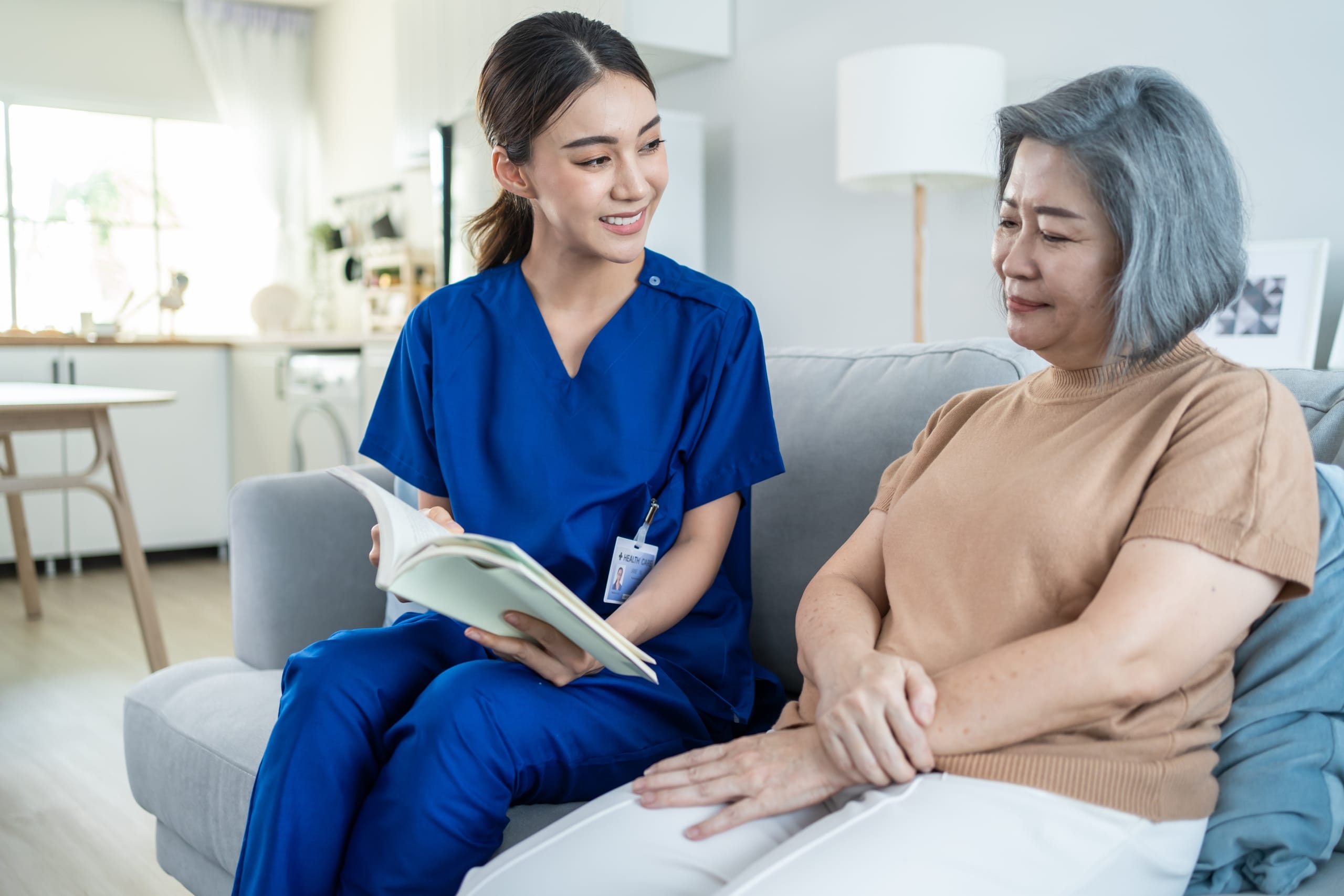 Asian nurse speaking with an elderly female woman