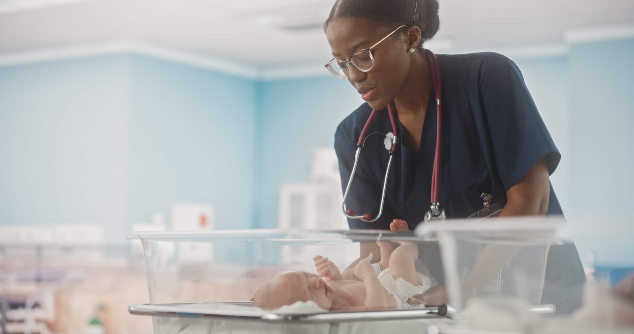 African-American NICU nurse holding a newborn baby