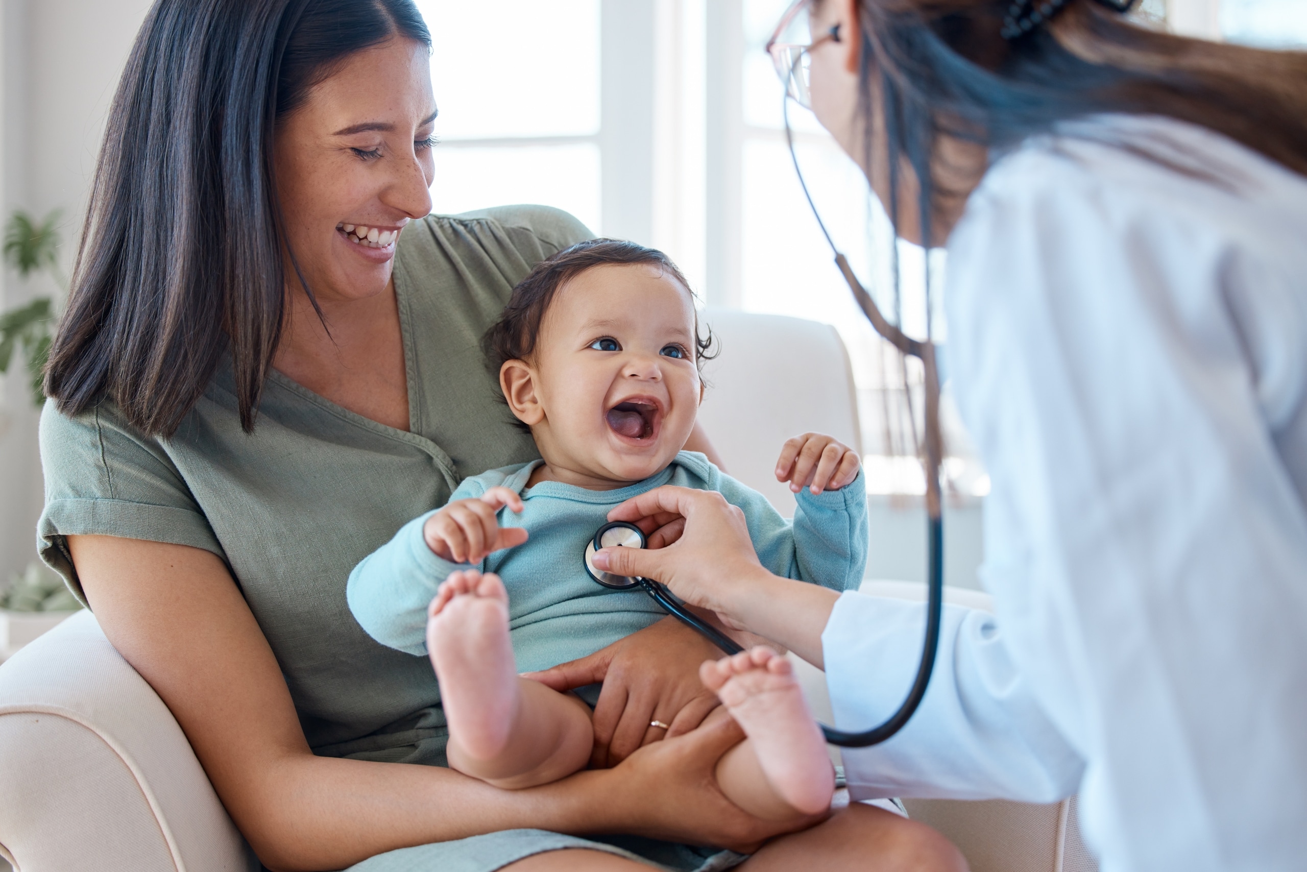 Pediatric nurse listening to a baby's heartbeat with a stethoscope